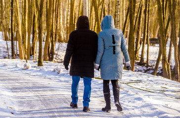 A guy and a girl walking in winter Park
