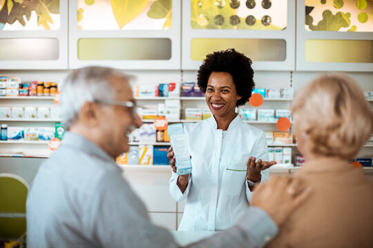 Pharmacist assisting senior couple with medication choice in pharmacy