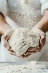 Selbstklebende Fototapeten Flour sprinkled over ball of dough held in hands. Bakery scene shows chef preparing dough in bright kitchen. Rustic bread preparation in traditional bakery. Focus on ingredients like flour, dough, © Maryna