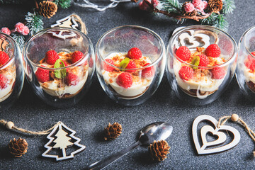 Verrine of crushed speculoos, mascarpone and raspberries on a gray background decorated for Christmas