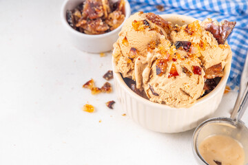 Creme brulee ice cream topped with caramelized sugar, sweet creamy gelato with a lot of crunchy caramel pieces and extra portion on top