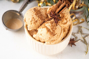 Portioned bowl with Christmas Eggnog ice cream scoops with cinnamon and spices, cold sweet gelato dessert for festive snack