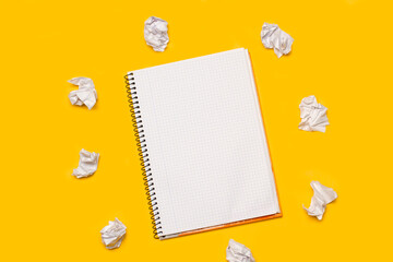 A spiral squared notepad surrounded by paper buns on a yellow background