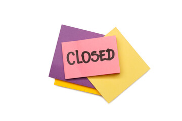 Closed single word handwritten on a pink adhesive paper note on a pile of colored paper notes on a...
