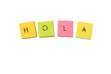 Hola single word handwritten on colored sticky paper blocks on a white background with copy space (trad. hello) © Mercedes Fittipaldi