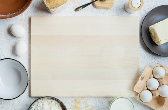 Light cutting board and baking ingredients on table
