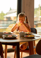 Little girl drinking orange juice at breakfast