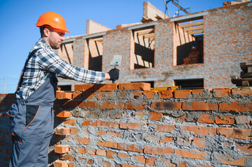 Portrait of a builder in the process of working on a construction site outdoors