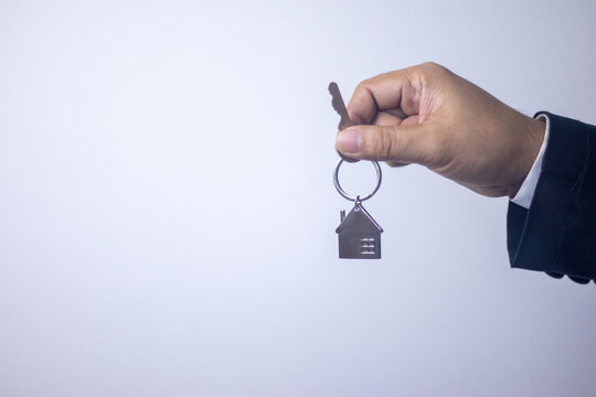 Real estate agent gives keys to new house on white background
