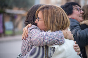 People hugging and greeting each other outdoors. Friends meeting, positive moments, bonding, togetherness