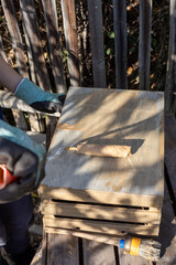 a child paints a wooden box with brushes in the garden