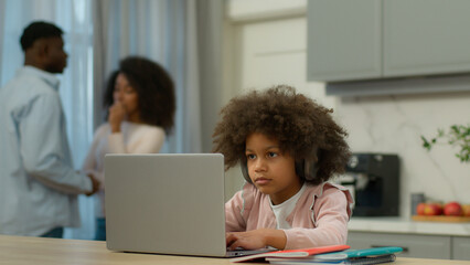 African American little girl pupil daughter child kid studying learning at home kitchen e-learning study with laptop computer app serious parents mother father talk together discuss childcare family