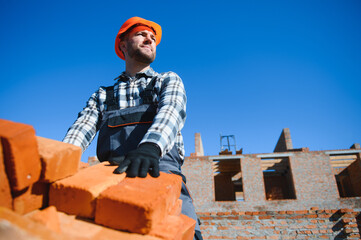 Portrait of a builder in the process of working on a construction site outdoors