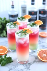 Fototapeta premium Cuatro vasos altos con cócteles de capas de colores decorados con rodajas de naranja y hojas de menta fresca. Fondo con botellas de licor y hierbas. 