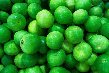 Fresh ripe green limes as background, top view