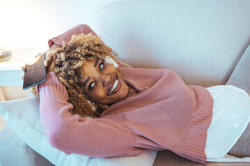 Young Woman Relaxing on Couch With Headphones and Smartphone