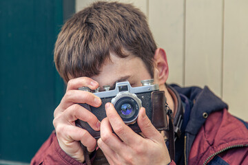 A young man takes pictures on a vintage camera. Film camera photography.