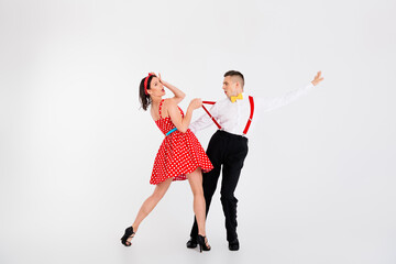 Full size portrait of two young rock and roll dancers flirty pull suspenders isolated on white...