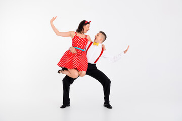 Full size portrait of two young rock and roll dancers hold hands rejoice isolated on white color background