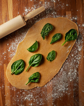 Homemade egg pasta with spinach and rolling pin
