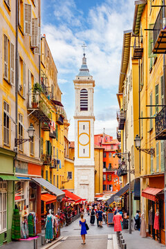 Fototapeta NICE, FRANCE: picturesque narrow streets of the old town, Vieux Nice, busy small shops and colorful facades of traditional houses, bell tower of Sainte Reparate church