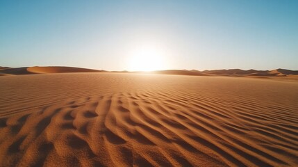 Serene desert landscape at sunrise with rippled sand dunes.