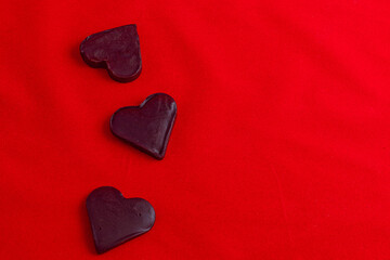 Fototapeta premium Valentine's Day celebration composition, chocolate hearts on a red background