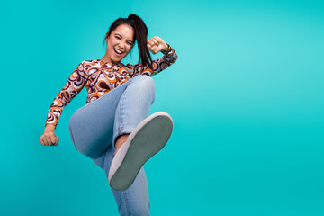 Photo portrait of lovely young lady kick fight step dance dressed stylish colorful clothes isolated on cyan color background