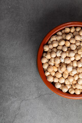 Earthenware bowl full of chickpeas on a kitchen worktop in a zenithal photograph