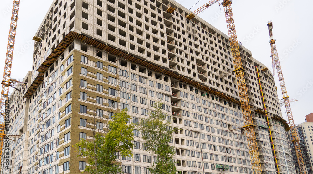 Poster large residential building rising with cranes and scaffolding while workers manage operations in a b