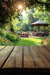 Empty wooden table in front of blurred summer garden. People picnic in gazebo in background. Green plants, flowers visible in garden. Ideal for products food against natural summer background.