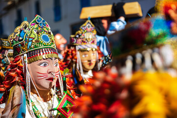 Dancers with masks and traditional costumes celebrate the festivity of the Virgen del Carmen in the square of Paucartambo. Cusco Peru.