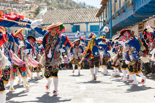 Dancers with masks and traditional costumes celebrate the festivity of the Virgen del Carmen in the square of Paucartambo. Cusco Peru.