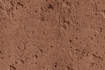 Mocha Mousse color of year 2025 textured concrete wall with space for text