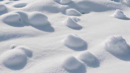 Obraz premium Snowdrifts creating an uneven surface on a sunny winter day