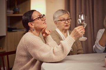 Wine degustation. Elderly women meeting and warmly-lit restaurant, attending degustation event and drinking, tasting delicious wine. Concept of elderly lifestyle, positive emotions, event