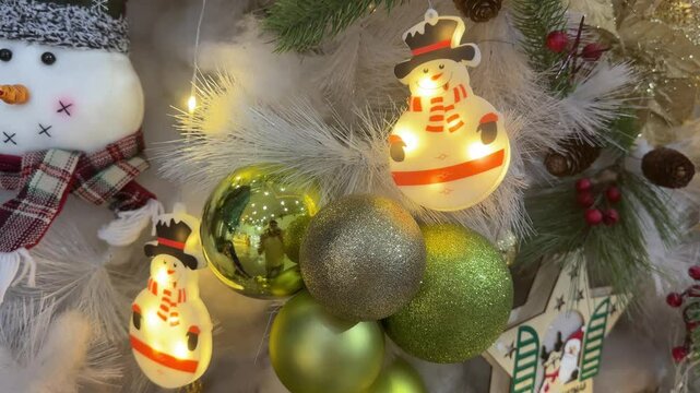 4k footage close up of lighted Christmas tree ornaments and decorations. Mistletoe, baubles, and bell with Interactive sparkling christmas twinkle lights or icicle lights.