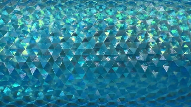 4k footage close up of beautiful shimmering reflective geometric triangular snake skin crystal texture in blue aquamarine or teal or tosca color. Deep blue tosca color geometrical seamless texture.