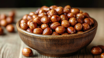 Obraz premium Tasty hazelnuts in wooden bowl on rustic wooden background, showcasing their rich texture and color, perfect for healthy snacking or culinary use