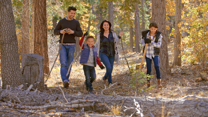 Active Family Outdoors Enjoying Autumn Or Fall Walk In Forest Together