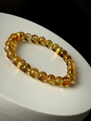 a stylish bracelet made of natural stones with an amulet and inserts made of silver and gold