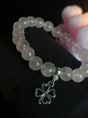 a stylish bracelet made of natural stones with an amulet and inserts made of silver and gold