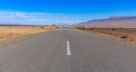 Long road through the Moroccan desert along the Atlas Mountains