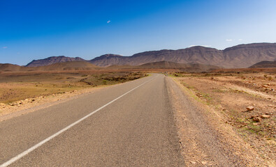 Long road through the Moroccan desert along the Atlas Mountains