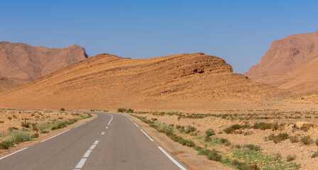 Long road through the Moroccan desert along the Atlas Mountains