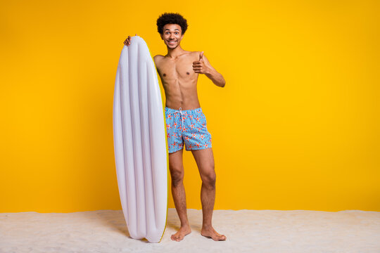 Young man enjoying summer vacation with inflatable mattress on a yellow background. Happy and carefree