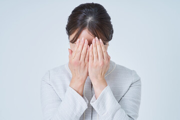 両手で顔を覆う女性