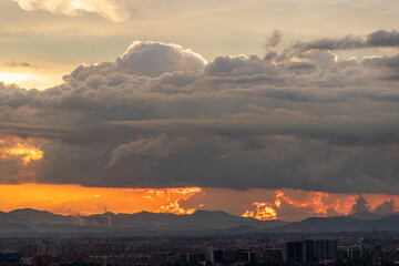 Atardecer dramático sobre Bogotá con nubes densas y paisaje urbano