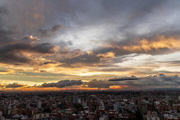 Atardecer dramático sobre Bogotá con nubes densas y paisaje urbano