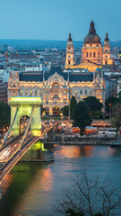 Fototapeta premium The photo shows evening Budapest with the illuminated Chain Bridge and St. Stephen's Basilica in the background, highlighting the city's charm and architectural beauty